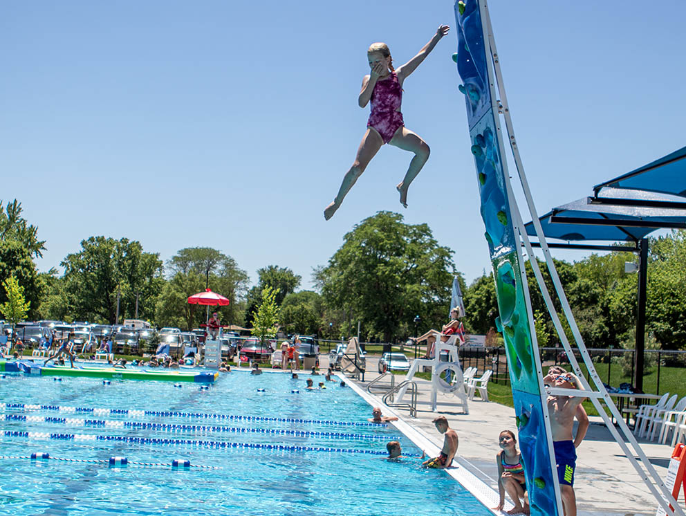 Girl jumping from climbing wall.